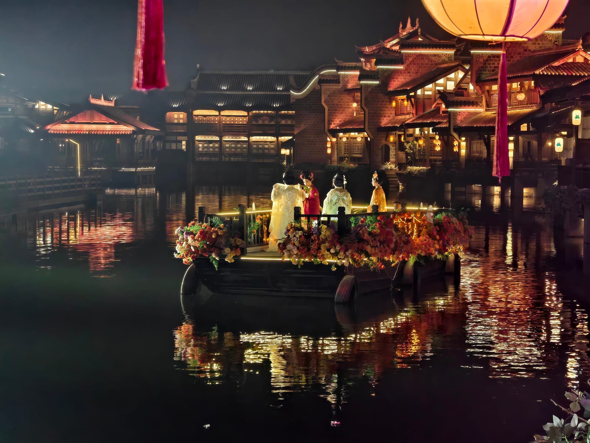 Una barca con viaggiatori in abiti tradizionali sul canale di Lizhuang, illuminato di notte.